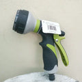 Green and gray garden hose spray nozzle with a label on a light gray background